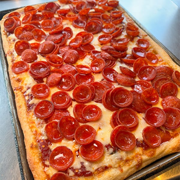 A rectangular pepperoni pizza from Spaghettini Pizza Trattoria, with a crispy crust and melted cheese.