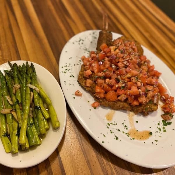 Spaghettini Pizza Trattoria's breaded chicken cutlet topped with diced tomatoes and a side of asparagus.